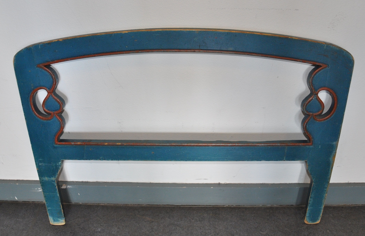 Uttrekkbar barneseng av tre, i to deler. Sengen er malt blå med dekorative røde linjer ved kanter. Hode- og endegavel har kurvet form øverst, og fylling på utsiden. Det er malt dekor på utsiden av endegavel og sideplater, og på innsiden av hodegavel. Motiv på maling av to fugler og sol på hodegavel, to trær og Sør-Fron kirke på endegavel og kuer og trær på sidegavler. Spesielt på hodegavel er malingen avlitt. Det følger med en løs sengehest med sveifet dekor.