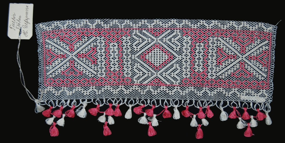 Nätet knutet med 4 tr, blekt lingarn. Mönstret trätt med 1 tråd ljusrött och 2 trådar blekt 1 tr lingarn. Div. geometriska figurer. Iknuten kläppfrans av blekt och ljusrött 1 tr lingarn vid ena långsidan. Rund pappersetikett med tryckt text: Gestriklands hemslöjdsförening, Gefle.