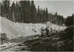 Grävarbete pågår vid en skärning på Trafikaktiebolaget Grängesberg - Oxelösunds Järnvägar, TGOJ:s banor.