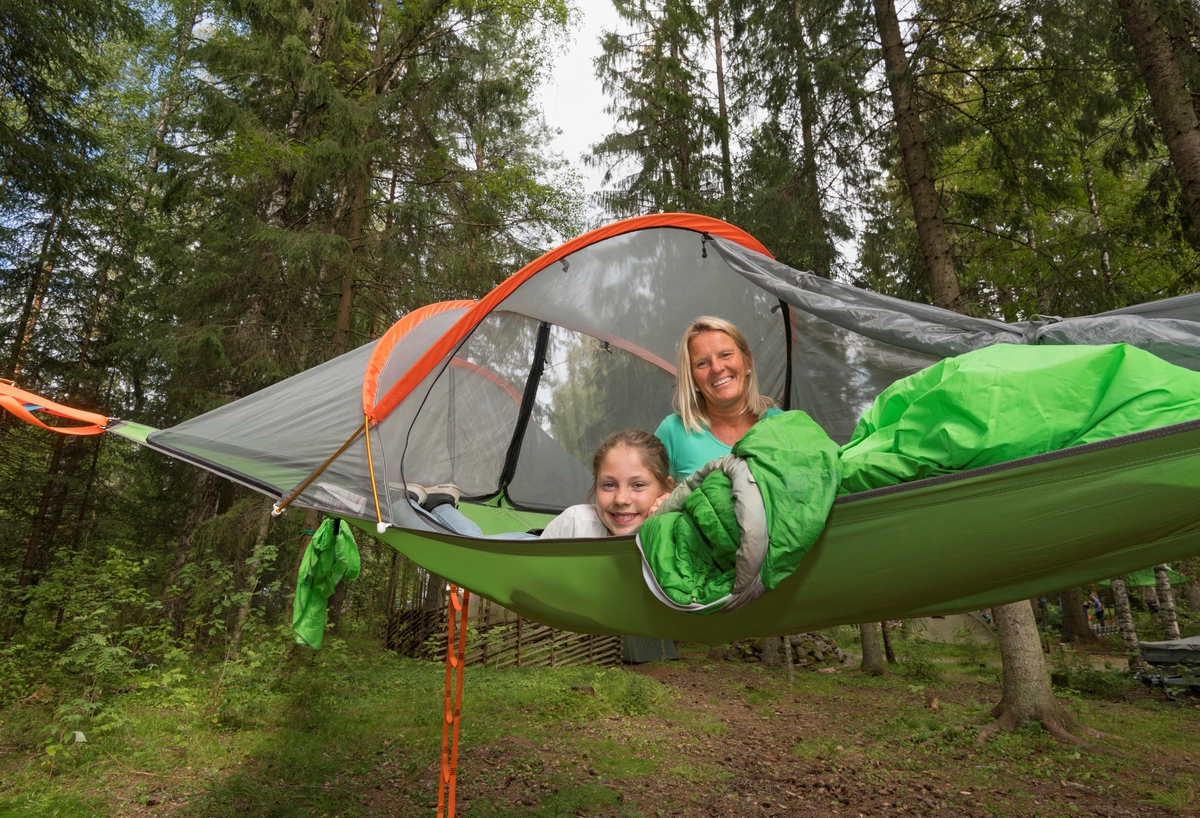 Kvinne og jente i tretopptelt fotografert under De nordiske jakt- og fiskedager 2019 på Norsk skogmuseum, Elverum, Hedmark. Telt. friluftsliv. DnT. Opplev Finnskogen. Tv.  Kristine Mathiasen, th. Torhild Riaúnet. De nordiske jakt- og fiskedagene 2019. Jakt- og fiskedagene. Jakt og fiskedagene. Jakt og fiskedager. Arrangement. Arrangementer. Camping. Telting.