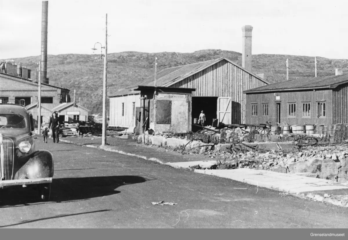 Kirkenes under gjenreisninga etter krigen, ca 1946. Wiullsgate sett mot Dampsentralen. Nærmest til høyre M. B. Johansens forretningsbrakke og deretter gamle BP-stasjonen. Til høyre i veikanten ser man hullet etter en bombe som gikk rett gjennom Tømmerstølgården og eksploderte i kjelleren til Folkets Frihet.