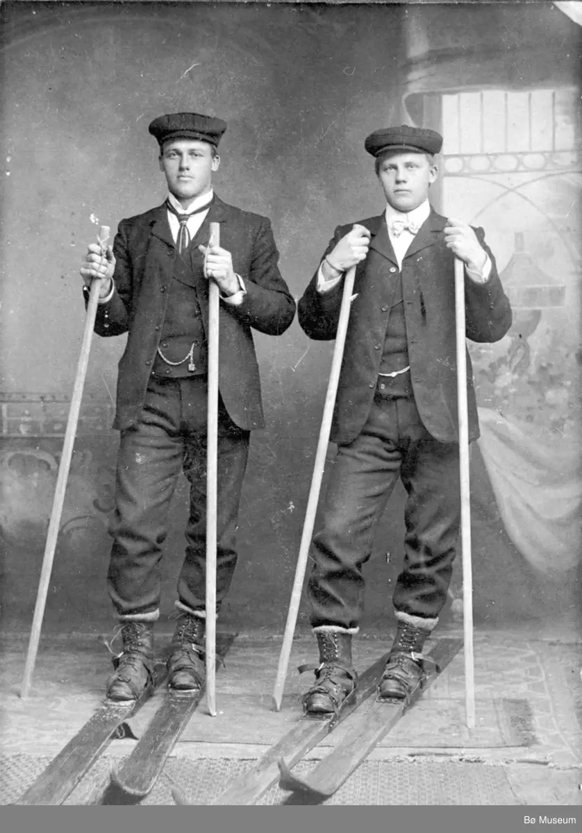 Helland Brothers, Knut G. Helland t.v. og Gunnar G. Helland t.h. på ski inne i eit fotoatelier.