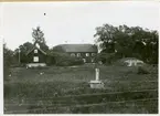 Munktorp sn, Köping kn, prästgården.
Gårdsbild med bl.a. staket och jordkällare och med pump i förgrunden. 1927.