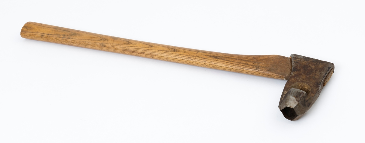 Øks - brukt til merking av fløtingstømmer i målings- og annammingsprosessen som foregikk langs vassdragene i overgangsfasen mellom vinter og vår, da tømmerstokkene etter måling formelt skiftet eier - fra skogeieren som hadde organisert hogst og framkjøring til sagbruk eller treforedlingsbedrift, som kjøpte tømmeret med sikte på videre bearbeiding til produkter som var salgbare på et større marked. 

Øksehodet (den smidde delen) er 13,5 centimeter høyt fra eggpartiet til nakken. Nakkedelen er 7,9 centimeter lang og om lag 2,6 centimeter bred bakerst, 2,2 centimeter i fronten. «Kjakene» - sideveggene rundt «øyet» (skafthullet) – smalner fra nakkepartiet mot den nedre delen av bladet. På den nedre delen av øksebladet er det en U-formet utsparing, og til endestavene (Knudsen-smedene kalte dem «stabler») er det påsveiset en cirka 3,7 centimeter høy fasslipt, profilegget «sko». Eggprofilen ble altså slått inn i yteveden på fløtingstømmeret, som tegn på hvem som eide stokkene. Øksehodet er, med unntak av den fasslipte eggen, lakkert med gulfarget lakk. Øverst på høyre side av øksehodet (sett i øksebrukerens perspektiv) finner vi stempelet «K. KNUDSEN MJØNDALEN» sammen med avbildninger av to medaljer denne smeden hadde oppnådd under vareutstillinger der han hadde vist produktene sine. Karl Henrik Knudsen (1870-1956) i Mjøndalen i Nedre Eiker patenterte denne typen merkeøkser i 1908.

Denne øksa har et drøyt 60,5 centimeter langt og forholdsvis rett treskaft (sannsynligvis ask eller hickory). Som økseskaft flest er det bredest i høyderetningen og smalest i bredderetningen i den fremre enden, og mer rundovalt bakerst. Den fremre enden av skaftet er kilet med en trekile som skulle redusere faren for at øksa løsnet fra skaftet under merkingsarbeidet.

Merkekart for Glomma knytter denne øksa til tømmer som ble annammet på vegne av firmaet Bay & Torp (merke nr. 223)

Litt generell informasjon om bruken av merkeøkser i skogbruket finnes under fanen «Opplysninger».