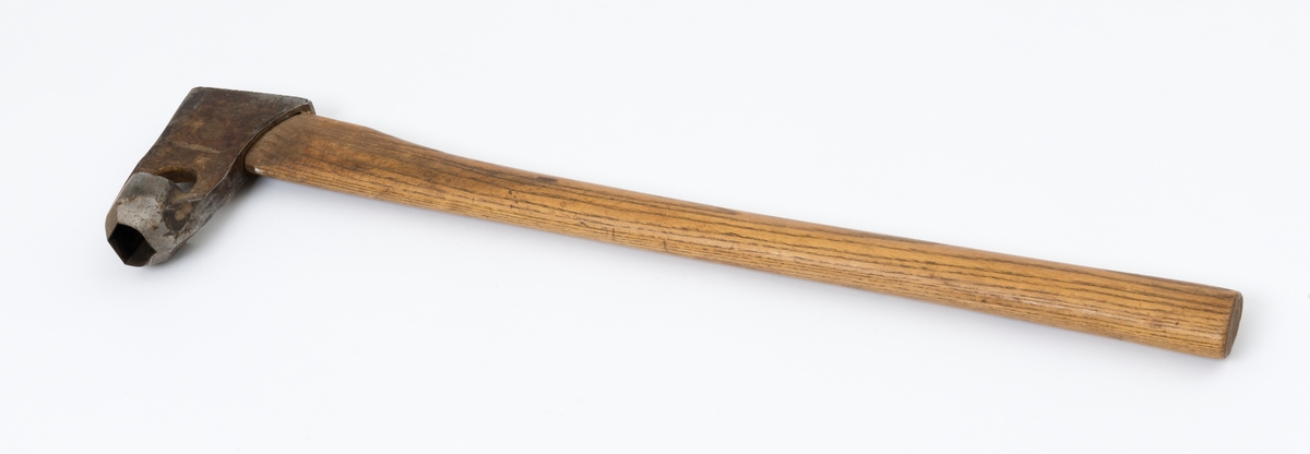 Øks - brukt til merking av fløtingstømmer i målings- og annammingsprosessen som foregikk langs vassdragene i overgangsfasen mellom vinter og vår, da tømmerstokkene etter måling formelt skiftet eier - fra skogeieren som hadde organisert hogst og framkjøring til sagbruk eller treforedlingsbedrift, som kjøpte tømmeret med sikte på videre bearbeiding til produkter som var salgbare på et større marked. 

Øksehodet (den smidde delen) er 13,5 centimeter høyt fra eggpartiet til nakken. Nakkedelen er 7,9 centimeter lang og om lag 2,6 centimeter bred bakerst, 2,2 centimeter i fronten. «Kjakene» - sideveggene rundt «øyet» (skafthullet) – smalner fra nakkepartiet mot den nedre delen av bladet. På den nedre delen av øksebladet er det en U-formet utsparing, og til endestavene (Knudsen-smedene kalte dem «stabler») er det påsveiset en cirka 3,7 centimeter høy fasslipt, profilegget «sko». Eggprofilen ble altså slått inn i yteveden på fløtingstømmeret, som tegn på hvem som eide stokkene. Øksehodet er, med unntak av den fasslipte eggen, lakkert med gulfarget lakk. Øverst på høyre side av øksehodet (sett i øksebrukerens perspektiv) finner vi stempelet «K. KNUDSEN MJØNDALEN» sammen med avbildninger av to medaljer denne smeden hadde oppnådd under vareutstillinger der han hadde vist produktene sine. Karl Henrik Knudsen (1870-1956) i Mjøndalen i Nedre Eiker patenterte denne typen merkeøkser i 1908.

Denne øksa har et drøyt 60,5 centimeter langt og forholdsvis rett treskaft (sannsynligvis ask eller hickory). Som økseskaft flest er det bredest i høyderetningen og smalest i bredderetningen i den fremre enden, og mer rundovalt bakerst. Den fremre enden av skaftet er kilet med en trekile som skulle redusere faren for at øksa løsnet fra skaftet under merkingsarbeidet.

Merkekart for Glomma knytter denne øksa til tømmer som ble annammet på vegne av firmaet Bay & Torp (merke nr. 223)

Litt generell informasjon om bruken av merkeøkser i skogbruket finnes under fanen «Opplysninger».