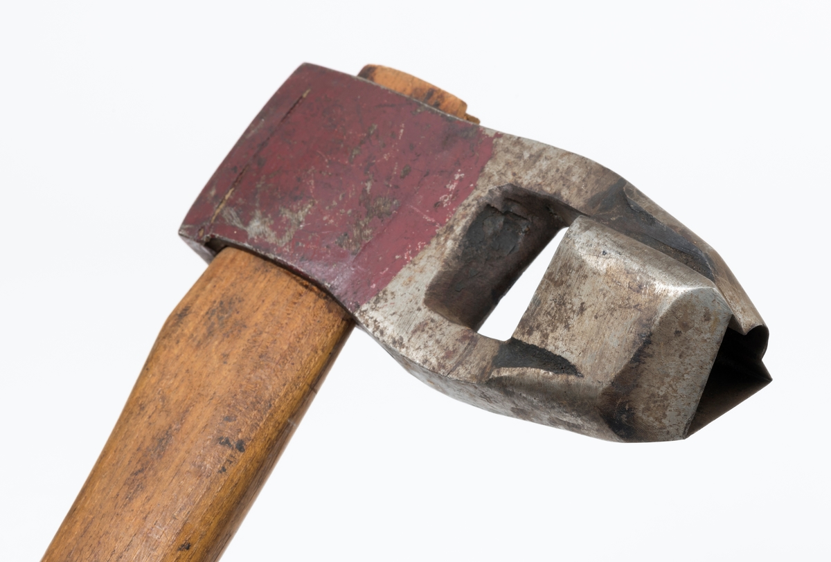 Øks - brukt til merking av fløtingstømmer i målings- og annammingsprosessen som foregikk langs vassdragene i overgangsfasen mellom vinter og vår, da tømmerstokkene etter måling formelt skiftet eier - fra skogeieren som hadde organisert hogst og framkjøring til sagbruk eller treforedlingsbedrift, som kjøpte tømmeret med sikte på videre bearbeiding til produkter som var salgbare på et større marked. 

Øksehodet (den smidde delen) er 16,3 centimeter høyt fra eggpartiet til nakken. Nakkedelen er 6,0 centimeter lang og om lag 2,6 centimeter bred. «Kjakene» - sideveggene rundt «øyet» (skafthullet) – er forholdsvis rette. På den nedre delen av øksebladet er det en U-formet utsparing, og til endestavene (Knudsen-smedene kalte dem «stabler») er det påsveiset en cirka 4,6 centimeter høy fasslipt, profilegget «sko». Eggprofilen er en trekant med en halvsirkelformet utbuktning på ei av sideflatene. Dette symbolet ble altså slått inn i yteveden på fløtingstømmeret, som tegn på hvem som eide stokkene. Den øvre delen av øksehodet er lakkert med rød lakk. På venstre side av dette øksebladet (sett i øksebrukerens perspektiv) finner vi smedstempelet «K. KNUDSEN  PATENT  MJØNDALEN». Smeden Karl Henrik Knudsen (1870-1956) tok patent på denne typen merkeøkser i 1908.

Øksa har et 60 centimeter langt og forholdsvis rett treskaft (sannsynligvis ask eller hickory). Som økseskaft flest er det bredest i høyderetningen og smalest i bredderetningen i den fremre enden, og mer rundovalt bakerst. Den fremre enden av skaftet er kilet med en trekile som skulle redusere faren for at øksa løsnet fra skaftet under merkingsarbeidet. Den venstre skaftsida har vært påført et navn ved hjelp av et svijernstempel.  Navnet er imidlertid forsøkt fjernet ved hjelp av ei rasp, antakelig fordi det firmaet som opprinnelig fikk tømmeret sitt merket med denne øksa ble avviklet, slik at merket muligens ble overtatt av en annen virksomhet. Det kan se ut til å ha stått «GL. KUR KOMPANI».

Litt generell informasjon om bruken av merkeøkser i skogbruket finnes under fanen «Opplysninger».