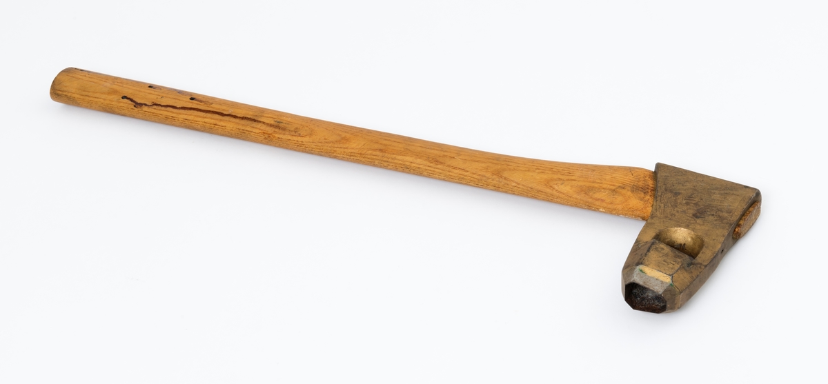 Øks - brukt til merking av fløtingstømmer i målings- og annammingsprosessen som foregikk langs vassdragene i overgangsfasen mellom vinter og vår, da tømmerstokkene etter måling formelt skiftet eier - fra skogeieren som hadde organisert hogst og framkjøring til sagbruk eller treforedlingsbedrift, som kjøpte tømmeret med sikte på videre bearbeiding til produkter som var salgbare på et større marked. 

Øksehodet (den smidde delen) er 13,1 centimeter høyt fra eggpartiet til nakken. Nakkedelen er 8,2 centimeter lang og om lag 2,5 centimeter bred bakerst, 2,2 centimeter i fronten. «Kjakene» - sideveggene rundt «øyet» (skafthullet) – smalner fra nakkepartiet mot den nedre delen av bladet. På den nedre delen av øksebladet er det en U-formet utsparing, og til endestavene (Knudsen-smedene kalte dem «stabler») er det påsveiset en cirka 3,8 centimeter høy fasslipt, profilegget «sko». Eggprofilen er en noe avlang åttekant (oktogon). Dette symbolet ble altså slått inn i yteveden på fløtingstømmeret, som tegn på hvem som eide stokkene. Øksehodet er, med unntak av den fasslipte eggen, lakkert med gulfarget lakk. Denne øksa har ikke noe smedstempel, men form og overflatebehandling tyder på at den er produsert av smeden Karl Henrik Knudsen (1870-1956) i Mjøndalen i Nedre Eiker.

Denne øksa har et 61 centimeter langt og forholdsvis rett treskaft (sannsynligvis ask eller hickory). Som økseskaft flest er det bredest i høyderetningen og smalest i bredderetningen i den fremre enden, og mer rundovalt bakerst. Den fremre enden av skaftet er kilet med en trekile som skulle redusere faren for at øksa løsnet fra skaftet under merkingsarbeidet.

Ifølge «Merkekart 1953 for Glommen» (gjengitt i Julius Nygaards skogalmanakk for 1954) ble dette merket brukt av Fetsund lenser i Glommavassdraget (jfr. merke nr. 35).

Litt generell informasjon om bruken av merkeøkser i skogbruket finnes under fanen «Opplysninger».