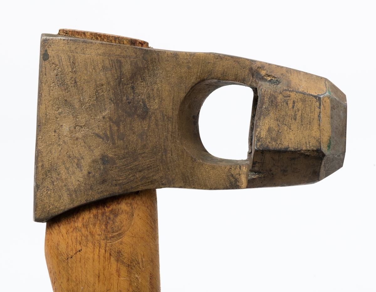 Øks - brukt til merking av fløtingstømmer i målings- og annammingsprosessen som foregikk langs vassdragene i overgangsfasen mellom vinter og vår, da tømmerstokkene etter måling formelt skiftet eier - fra skogeieren som hadde organisert hogst og framkjøring til sagbruk eller treforedlingsbedrift, som kjøpte tømmeret med sikte på videre bearbeiding til produkter som var salgbare på et større marked. 

Øksehodet (den smidde delen) er 13,1 centimeter høyt fra eggpartiet til nakken. Nakkedelen er 8,2 centimeter lang og om lag 2,5 centimeter bred bakerst, 2,2 centimeter i fronten. «Kjakene» - sideveggene rundt «øyet» (skafthullet) – smalner fra nakkepartiet mot den nedre delen av bladet. På den nedre delen av øksebladet er det en U-formet utsparing, og til endestavene (Knudsen-smedene kalte dem «stabler») er det påsveiset en cirka 3,8 centimeter høy fasslipt, profilegget «sko». Eggprofilen er en noe avlang åttekant (oktogon). Dette symbolet ble altså slått inn i yteveden på fløtingstømmeret, som tegn på hvem som eide stokkene. Øksehodet er, med unntak av den fasslipte eggen, lakkert med gulfarget lakk. Denne øksa har ikke noe smedstempel, men form og overflatebehandling tyder på at den er produsert av smeden Karl Henrik Knudsen (1870-1956) i Mjøndalen i Nedre Eiker.

Denne øksa har et 61 centimeter langt og forholdsvis rett treskaft (sannsynligvis ask eller hickory). Som økseskaft flest er det bredest i høyderetningen og smalest i bredderetningen i den fremre enden, og mer rundovalt bakerst. Den fremre enden av skaftet er kilet med en trekile som skulle redusere faren for at øksa løsnet fra skaftet under merkingsarbeidet.

Ifølge «Merkekart 1953 for Glommen» (gjengitt i Julius Nygaards skogalmanakk for 1954) ble dette merket brukt av Fetsund lenser i Glommavassdraget (jfr. merke nr. 35).

Litt generell informasjon om bruken av merkeøkser i skogbruket finnes under fanen «Opplysninger».