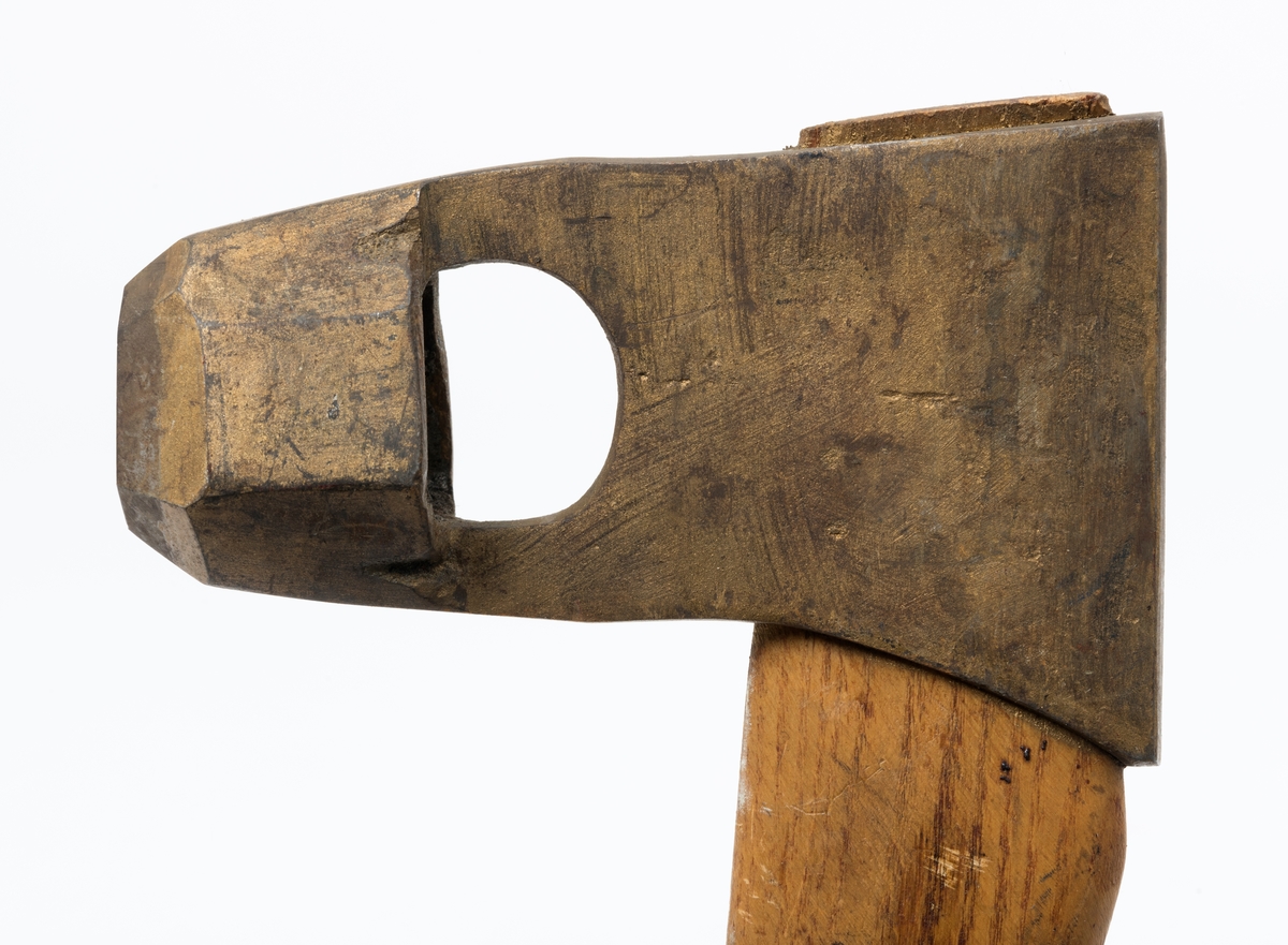 Øks - brukt til merking av fløtingstømmer i målings- og annammingsprosessen som foregikk langs vassdragene i overgangsfasen mellom vinter og vår, da tømmerstokkene etter måling formelt skiftet eier - fra skogeieren som hadde organisert hogst og framkjøring til sagbruk eller treforedlingsbedrift, som kjøpte tømmeret med sikte på videre bearbeiding til produkter som var salgbare på et større marked. 

Øksehodet (den smidde delen) er 13,1 centimeter høyt fra eggpartiet til nakken. Nakkedelen er 8,2 centimeter lang og om lag 2,5 centimeter bred bakerst, 2,2 centimeter i fronten. «Kjakene» - sideveggene rundt «øyet» (skafthullet) – smalner fra nakkepartiet mot den nedre delen av bladet. På den nedre delen av øksebladet er det en U-formet utsparing, og til endestavene (Knudsen-smedene kalte dem «stabler») er det påsveiset en cirka 3,8 centimeter høy fasslipt, profilegget «sko». Eggprofilen er en noe avlang åttekant (oktogon). Dette symbolet ble altså slått inn i yteveden på fløtingstømmeret, som tegn på hvem som eide stokkene. Øksehodet er, med unntak av den fasslipte eggen, lakkert med gulfarget lakk. Denne øksa har ikke noe smedstempel, men form og overflatebehandling tyder på at den er produsert av smeden Karl Henrik Knudsen (1870-1956) i Mjøndalen i Nedre Eiker.

Denne øksa har et 61 centimeter langt og forholdsvis rett treskaft (sannsynligvis ask eller hickory). Som økseskaft flest er det bredest i høyderetningen og smalest i bredderetningen i den fremre enden, og mer rundovalt bakerst. Den fremre enden av skaftet er kilet med en trekile som skulle redusere faren for at øksa løsnet fra skaftet under merkingsarbeidet.

Ifølge «Merkekart 1953 for Glommen» (gjengitt i Julius Nygaards skogalmanakk for 1954) ble dette merket brukt av Fetsund lenser i Glommavassdraget (jfr. merke nr. 35).

Litt generell informasjon om bruken av merkeøkser i skogbruket finnes under fanen «Opplysninger».