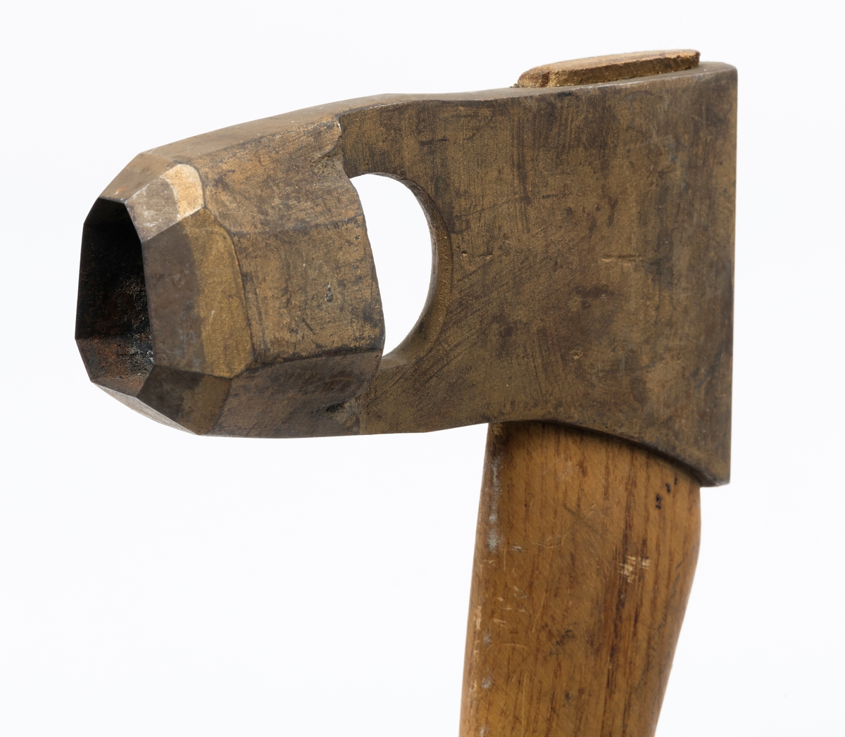 Øks - brukt til merking av fløtingstømmer i målings- og annammingsprosessen som foregikk langs vassdragene i overgangsfasen mellom vinter og vår, da tømmerstokkene etter måling formelt skiftet eier - fra skogeieren som hadde organisert hogst og framkjøring til sagbruk eller treforedlingsbedrift, som kjøpte tømmeret med sikte på videre bearbeiding til produkter som var salgbare på et større marked. 

Øksehodet (den smidde delen) er 13,1 centimeter høyt fra eggpartiet til nakken. Nakkedelen er 8,2 centimeter lang og om lag 2,5 centimeter bred bakerst, 2,2 centimeter i fronten. «Kjakene» - sideveggene rundt «øyet» (skafthullet) – smalner fra nakkepartiet mot den nedre delen av bladet. På den nedre delen av øksebladet er det en U-formet utsparing, og til endestavene (Knudsen-smedene kalte dem «stabler») er det påsveiset en cirka 3,8 centimeter høy fasslipt, profilegget «sko». Eggprofilen er en noe avlang åttekant (oktogon). Dette symbolet ble altså slått inn i yteveden på fløtingstømmeret, som tegn på hvem som eide stokkene. Øksehodet er, med unntak av den fasslipte eggen, lakkert med gulfarget lakk. Denne øksa har ikke noe smedstempel, men form og overflatebehandling tyder på at den er produsert av smeden Karl Henrik Knudsen (1870-1956) i Mjøndalen i Nedre Eiker.

Denne øksa har et 61 centimeter langt og forholdsvis rett treskaft (sannsynligvis ask eller hickory). Som økseskaft flest er det bredest i høyderetningen og smalest i bredderetningen i den fremre enden, og mer rundovalt bakerst. Den fremre enden av skaftet er kilet med en trekile som skulle redusere faren for at øksa løsnet fra skaftet under merkingsarbeidet.

Ifølge «Merkekart 1953 for Glommen» (gjengitt i Julius Nygaards skogalmanakk for 1954) ble dette merket brukt av Fetsund lenser i Glommavassdraget (jfr. merke nr. 35).

Litt generell informasjon om bruken av merkeøkser i skogbruket finnes under fanen «Opplysninger».