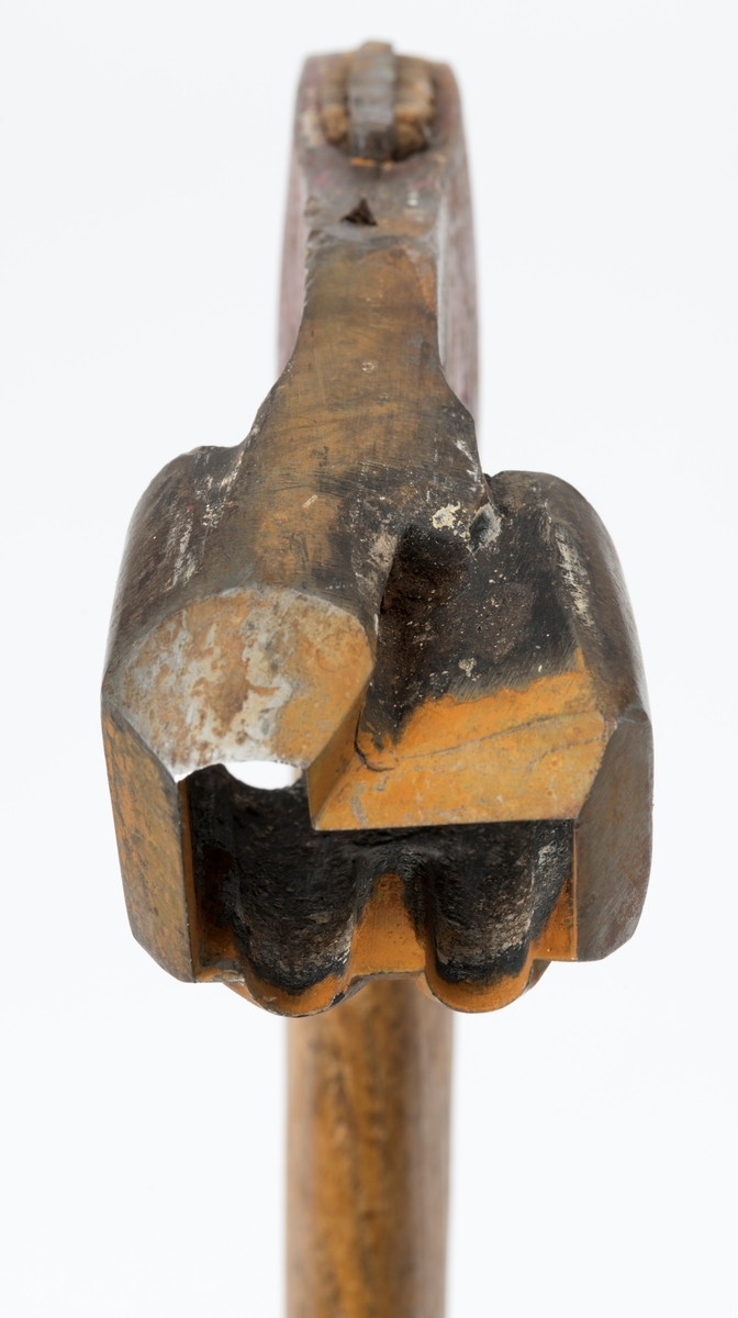 Øks – brukt til merking av fløtingstømmer i målings- og annammingsprosessen som foregikk langs vassdragene i overgangsfasen mellom vinter og vår, da tømmerstokkene etter måling formelt skiftet eier – fra skogeieren som hadde organisert hogst og framkjøring til sagbruk eller treforedlingsbedrift, som kjøpte tømmeret med sikte på videre bearbeiding til produkter som var salgbare på et større marked. 

Øksehodet (den smidde delen) er cirka 15,5 centimeter høyt fra eggpartiet til nakken. Nakkedelen er 6,4 centimeter lang og om lag 2,2 centimeter bred. «Kjakene» – sideveggene rundt «øyet» (skafthullet) – er forholdsvis rette. På den nedre delen av øksebladet er det en U-formet utsparing, og til endestavene (Knudsen-smedene kalte dem «stabler») er det påsveiset en cirka 4 centimeter høy fasslipt, profilegget «sko». Eggprofilen er formet som omrisset av et stilisert damplokomotiv. Dette symbolet ble altså slått inn i yteveden på fløtingstømmeret, som tegn på hvem som eide stokkene. Den øvre delen av øksehodet er lakkert med rød lakk. På venstre side av dette øksebladet (sett i øksebrukerens perspektiv) finner vi smedstempelet «K. KNUDSEN  PATENT». Smeden Karl Henrik Knudsen (1870-1956) tok patent på denne typen merkeøkser i 1908.

Øksa har et 61 centimeter langt og forholdsvis rett treskaft (sannsynligvis ask eller hickory) som er overflatebehandlet med rasp. Som økseskaft flest er det bredest i høyderetningen og smalest i bredderetningen i den fremre enden, og mer rundovalt bakerst. Den fremre enden av skaftet er kilet med en jernkile som skulle redusere faren for at øksa løsnet fra skaftet under merkingsarbeidet.

Ifølge «Merkekart 1953 for Glommen» (gjengitt i Julius Nygaards skogalmanakk for 1954) ble dette merket brukt av Norges Statsbaner (jfr. merke nr. 35). På merkekartet fra 1920 er det samme merket knyttet til firmaet Melsom & Holth.

Litt generell informasjon om bruken av merkeøkser i skogbruket finnes under fanen «Opplysninger».