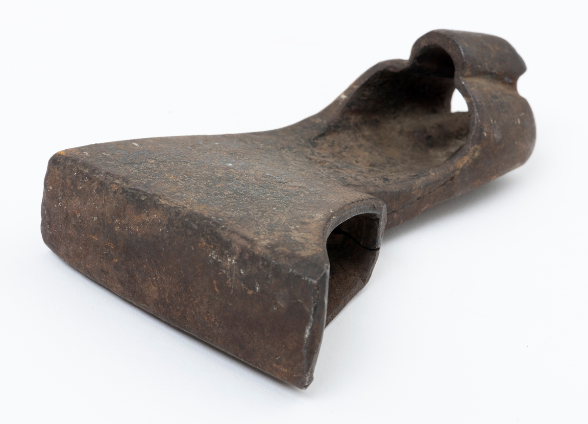 Øksehode – brukt til merking av fløtingstømmer i målings- og annammingsprosessen som foregikk langs vassdragene i overgangsfasen mellom vinter og vår, da tømmerstokkene etter måling formelt skiftet eier – fra skogeieren som hadde organisert hogst og framkjøring til sagbruk eller treforedlingsbedrift, som kjøpte tømmeret med sikte på videre bearbeiding til produkter som var salgbare på et større marked. 

Øksehodet (den smidde delen) er snaut 14,3 centimeter høyt fra eggpartiet til nakken. Nakkedelen er 9,0 centimeter lang og om lag 3,1 centimeter bred. «Kjakene» – sideveggene rundt «øyet» (skafthullet) – smalner mot den nedre delen av bladet. Det er en sprekk i godset i underkant av øyet. Nederst på bladet er det utsmidd en drøyt 3 centimeter høy fasslipt, profilegget «sko» (målet er tatt i ytterkant, der denne komponenten er smalest). Eggprofilen er formet som omrisset av en fugl med utspente vinger. Dette symbolet ble altså slått inn i yteveden på fløtingstømmeret, som tegn på hvem som eide stokkene. Øksehodet har ikke noe synlig smedstempel. Stålet er noe rustent. Bokstavene «OT» - antakelig smedens initialer - er antakelig smedens initialer.

Dette øksemerket ble ifølge merkekart for Glomma fra 1921 bruk til tømmer som ble innkjøpt på vegne av Lillestrøms Cellulosefabrik, en treforedlingsbedrift som var i virksomhet fra 1908 til 1943 (de første åra under navnet «Lillestrøm Sulfitfabrik»).

Litt generell informasjon om bruken av merkeøkser i skogbruket finnes under fanen «Opplysninger».