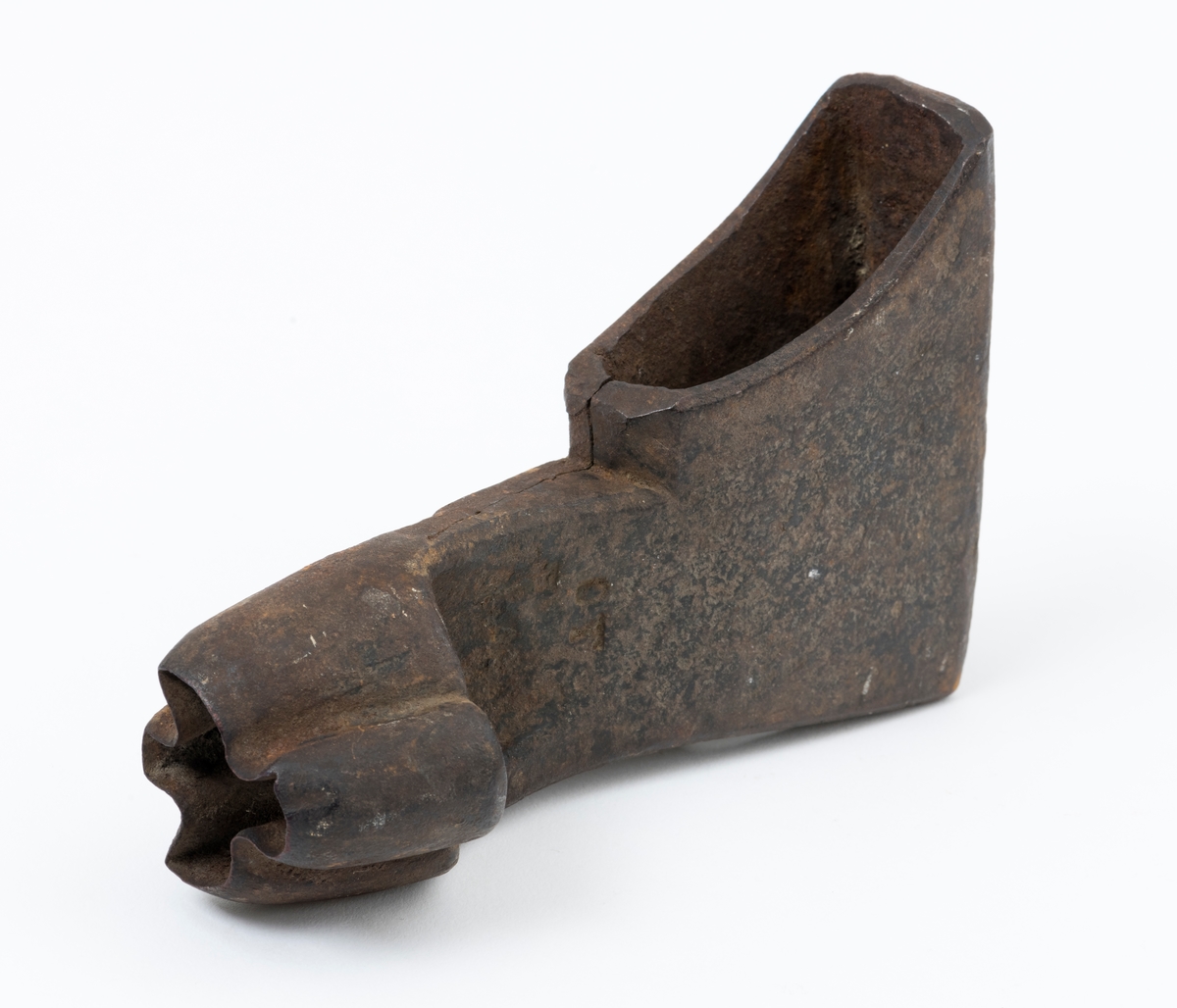 Øksehode – brukt til merking av fløtingstømmer i målings- og annammingsprosessen som foregikk langs vassdragene i overgangsfasen mellom vinter og vår, da tømmerstokkene etter måling formelt skiftet eier – fra skogeieren som hadde organisert hogst og framkjøring til sagbruk eller treforedlingsbedrift, som kjøpte tømmeret med sikte på videre bearbeiding til produkter som var salgbare på et større marked. 

Øksehodet (den smidde delen) er snaut 14,3 centimeter høyt fra eggpartiet til nakken. Nakkedelen er 9,0 centimeter lang og om lag 3,1 centimeter bred. «Kjakene» – sideveggene rundt «øyet» (skafthullet) – smalner mot den nedre delen av bladet. Det er en sprekk i godset i underkant av øyet. Nederst på bladet er det utsmidd en drøyt 3 centimeter høy fasslipt, profilegget «sko» (målet er tatt i ytterkant, der denne komponenten er smalest). Eggprofilen er formet som omrisset av en fugl med utspente vinger. Dette symbolet ble altså slått inn i yteveden på fløtingstømmeret, som tegn på hvem som eide stokkene. Øksehodet har ikke noe synlig smedstempel. Stålet er noe rustent. Bokstavene «OT» - antakelig smedens initialer - er antakelig smedens initialer.

Dette øksemerket ble ifølge merkekart for Glomma fra 1921 bruk til tømmer som ble innkjøpt på vegne av Lillestrøms Cellulosefabrik, en treforedlingsbedrift som var i virksomhet fra 1908 til 1943 (de første åra under navnet «Lillestrøm Sulfitfabrik»).

Litt generell informasjon om bruken av merkeøkser i skogbruket finnes under fanen «Opplysninger».