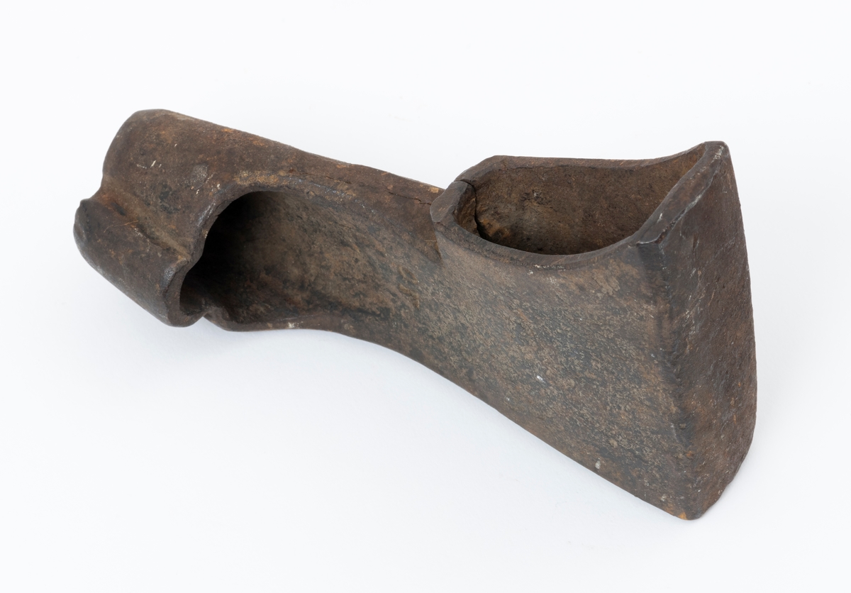 Øksehode – brukt til merking av fløtingstømmer i målings- og annammingsprosessen som foregikk langs vassdragene i overgangsfasen mellom vinter og vår, da tømmerstokkene etter måling formelt skiftet eier – fra skogeieren som hadde organisert hogst og framkjøring til sagbruk eller treforedlingsbedrift, som kjøpte tømmeret med sikte på videre bearbeiding til produkter som var salgbare på et større marked. 

Øksehodet (den smidde delen) er snaut 14,3 centimeter høyt fra eggpartiet til nakken. Nakkedelen er 9,0 centimeter lang og om lag 3,1 centimeter bred. «Kjakene» – sideveggene rundt «øyet» (skafthullet) – smalner mot den nedre delen av bladet. Det er en sprekk i godset i underkant av øyet. Nederst på bladet er det utsmidd en drøyt 3 centimeter høy fasslipt, profilegget «sko» (målet er tatt i ytterkant, der denne komponenten er smalest). Eggprofilen er formet som omrisset av en fugl med utspente vinger. Dette symbolet ble altså slått inn i yteveden på fløtingstømmeret, som tegn på hvem som eide stokkene. Øksehodet har ikke noe synlig smedstempel. Stålet er noe rustent. Bokstavene «OT» - antakelig smedens initialer - er antakelig smedens initialer.

Dette øksemerket ble ifølge merkekart for Glomma fra 1921 bruk til tømmer som ble innkjøpt på vegne av Lillestrøms Cellulosefabrik, en treforedlingsbedrift som var i virksomhet fra 1908 til 1943 (de første åra under navnet «Lillestrøm Sulfitfabrik»).

Litt generell informasjon om bruken av merkeøkser i skogbruket finnes under fanen «Opplysninger».