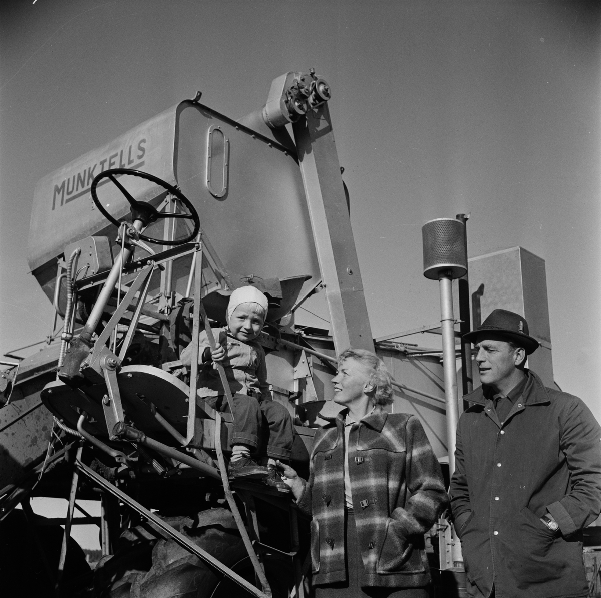 Uppländsk bonde, kvinna och barn vid skördetröska, Uppland 1955