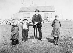 Frå Våland i Hå. Gamal mann med spade står saman med tre bor