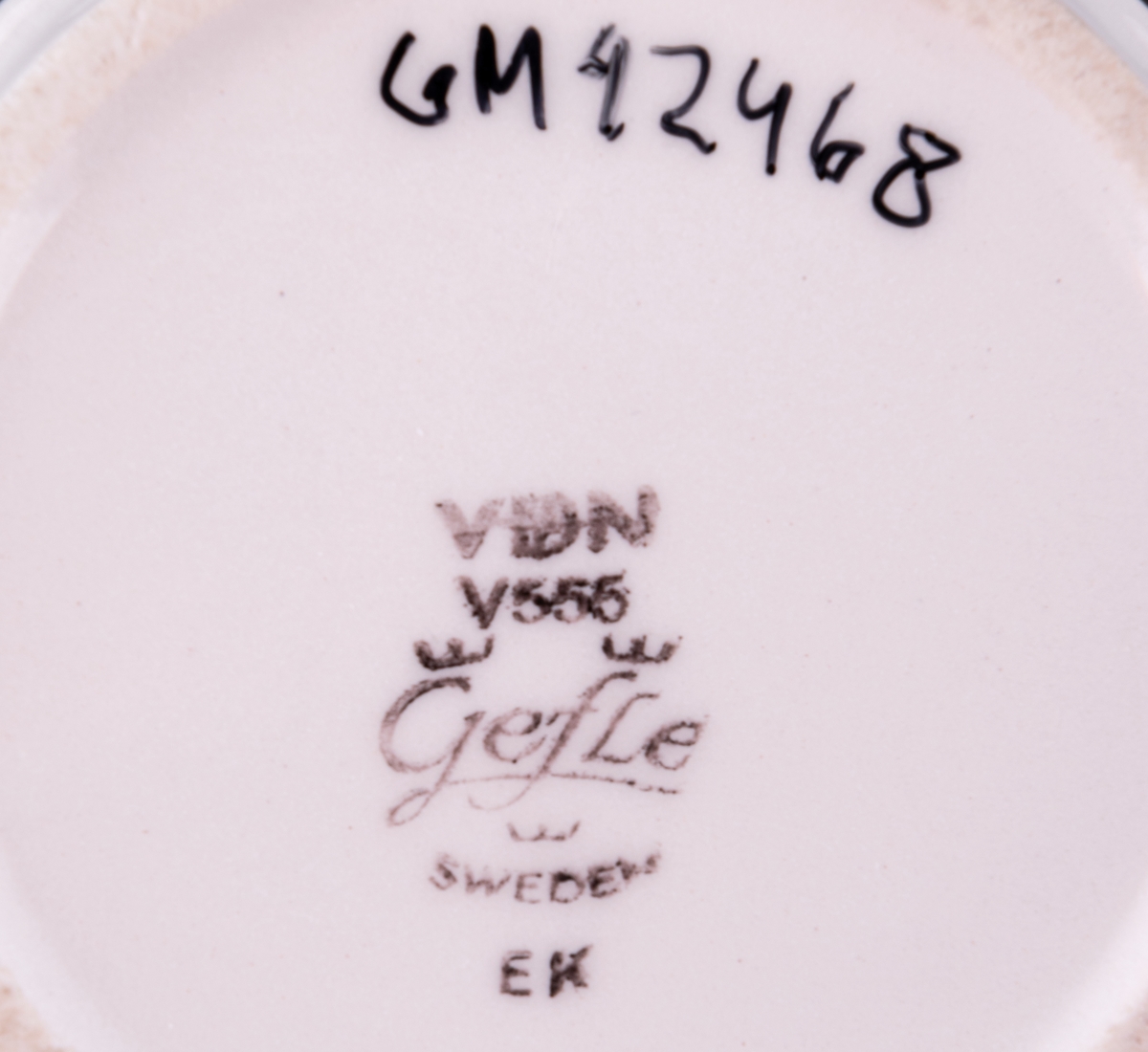 Kaffekopp med fat, modell EH i dekoren Ek. Dekor av Barbro Löfgren-Örtendahl. Runt koppen ett brunt och ett gult band med centrumtryck, fatet helt i brunt.