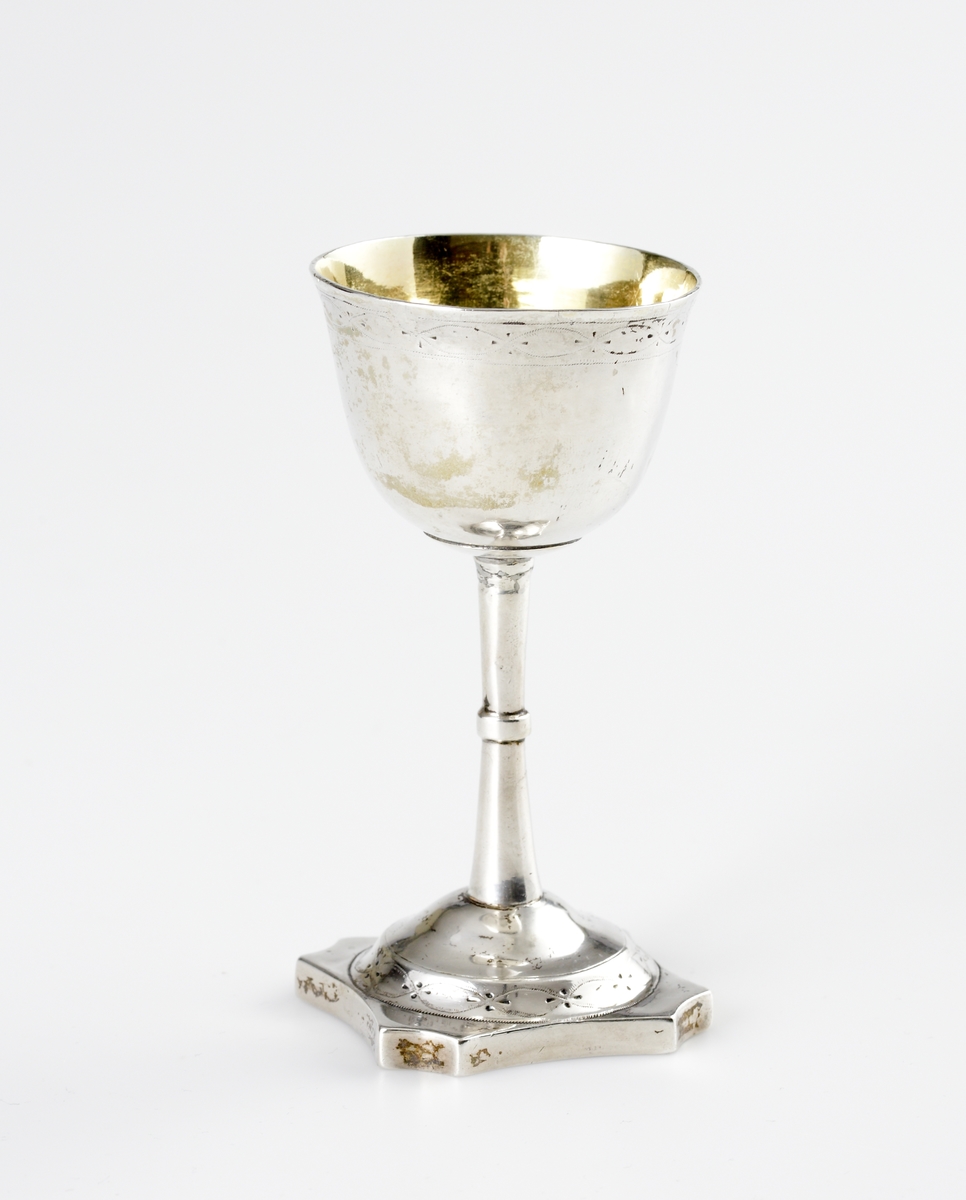 S.k. supkalk av silver, med ben och fot. 
Graverat mönster på skålens kant och på foten. Invändigt är cuppan förgylld. Foten är åttkantig. 
Stämplar (deformerade, svårtydda) i botten. 

Inskrivet i huvudkatalogen 1963.