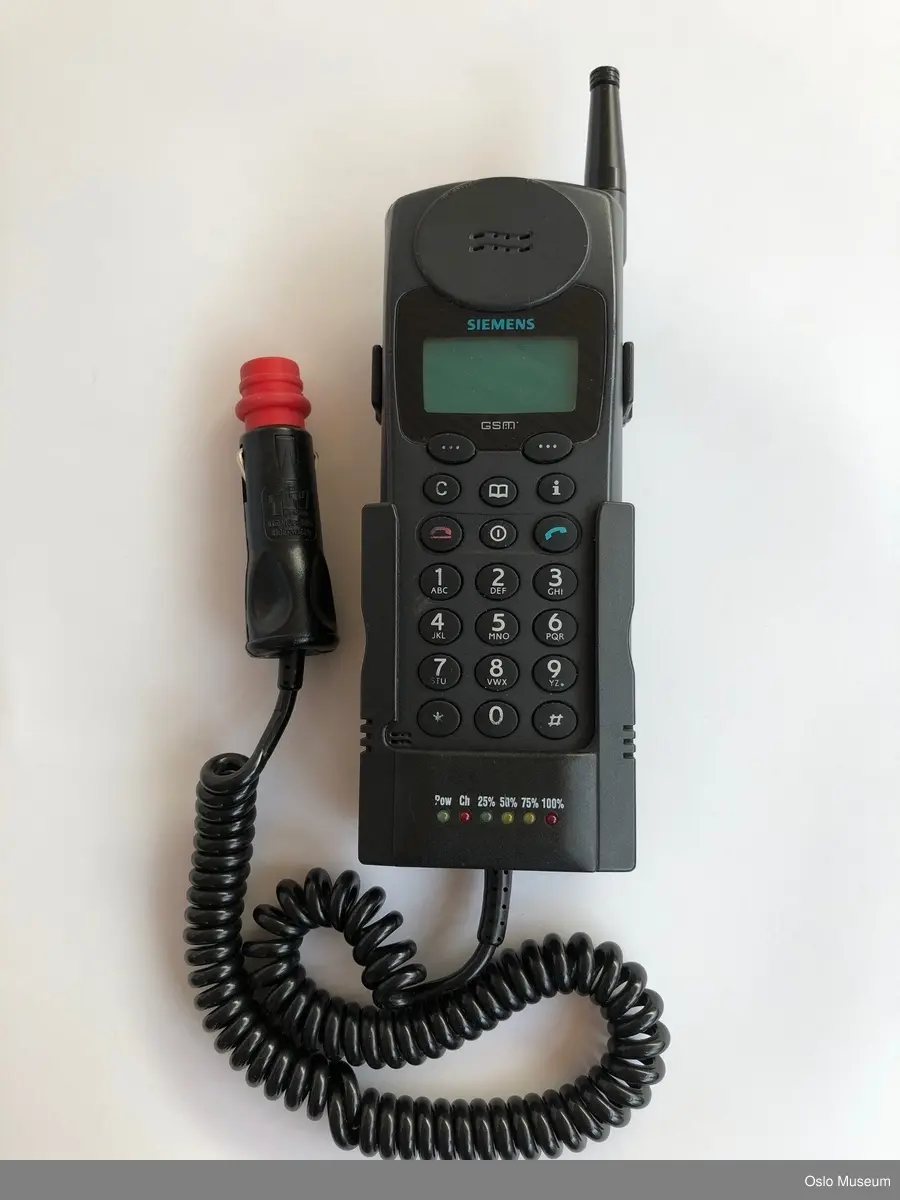 Mobiltelefon i plastmateriale med utenpåliggende taster og uttekkbar antenne. Lader med uttak til bil.