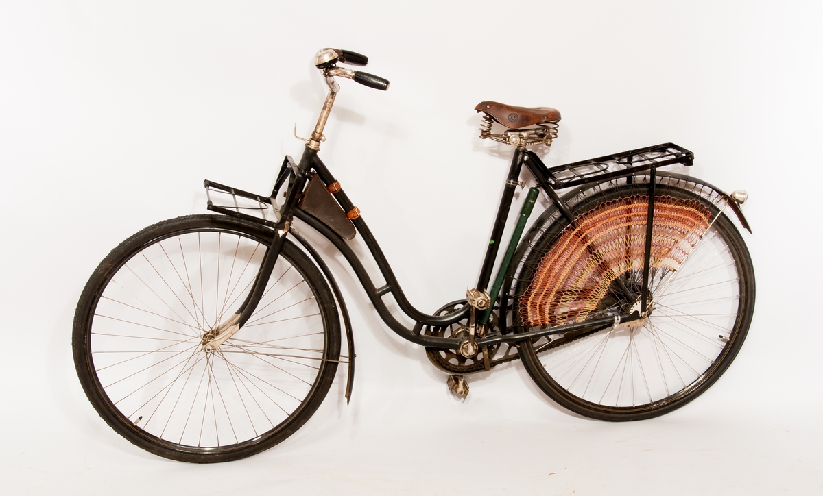 Damcykel av märket Drott, ramnummer 56461. Svartlackerad ram med dekorlinjer. Med sadel av läder märkt "V" samt 4192 A. Tillbehör: Registreringsskylt märkt 12857, ekerskydd, tillbehörsväska i läder,