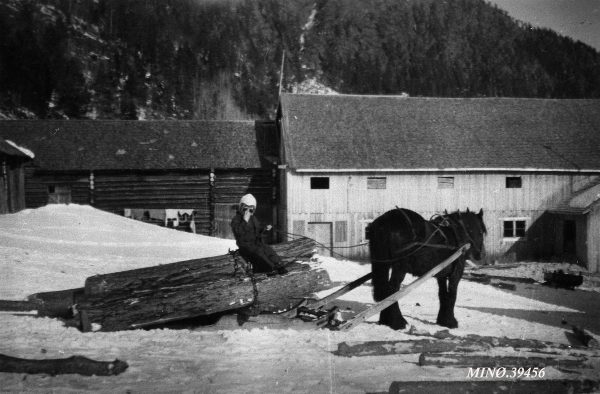 Barn sitter på tømmerlass