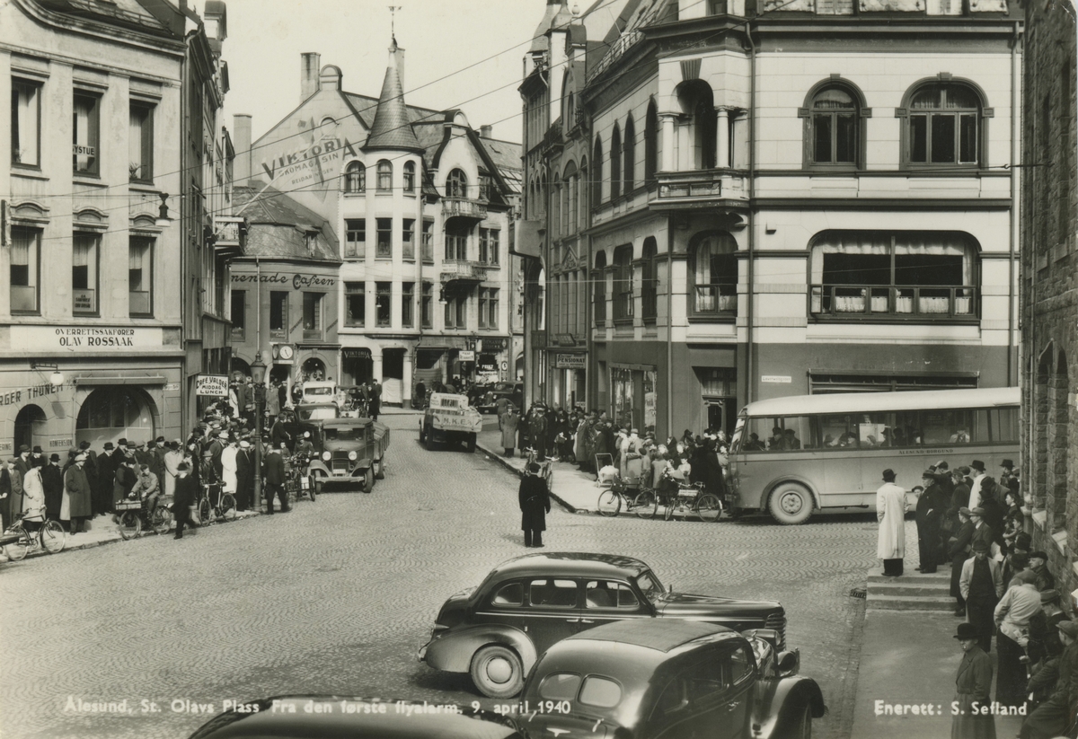 Motiv av gatemiljøet i Kongens gate, sett fra St. Olavs plass i Ålesund. Tidspunktet er under den første flyalarmen 9. april 1940.