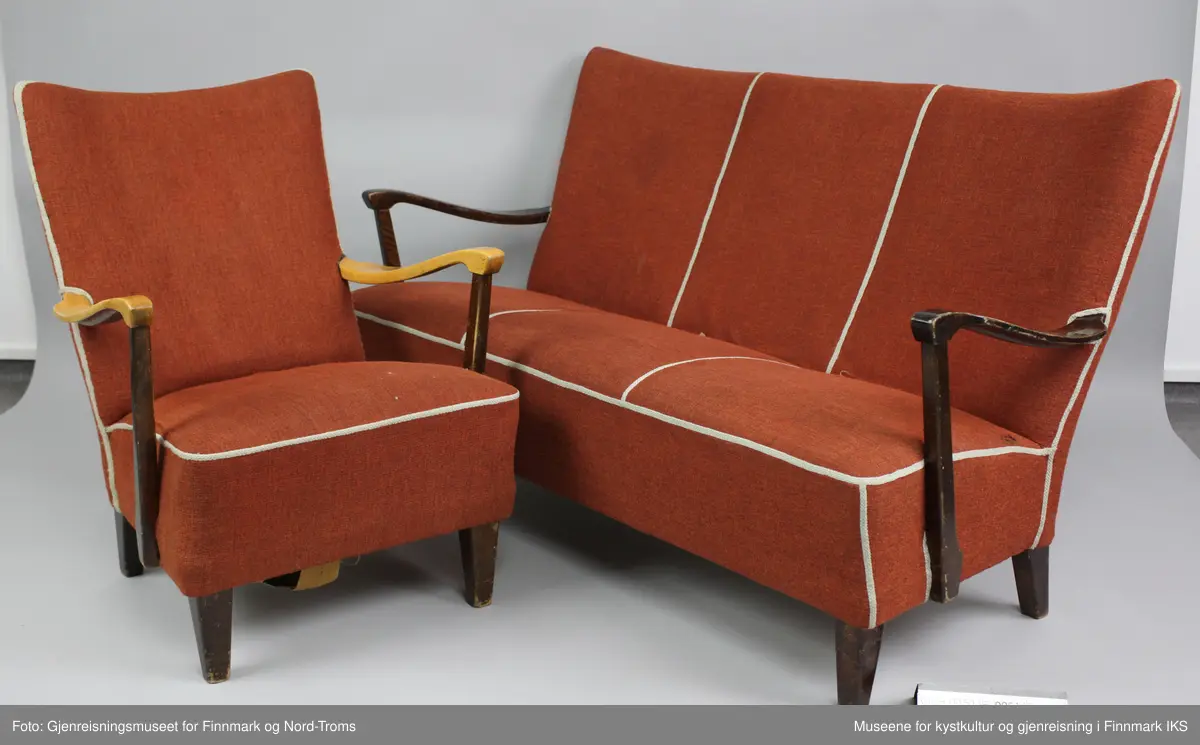 Sofaen er en treseter med polstring i rygg og sete. Den er trukket med rødt stoff og har naturfarget kantbånd som rammer inn hele møbelet. Kantbåndet deler også inn både rygg- og sete, i tre partier. Armlenene er buet og er festet i nedre delen av ryggen og i ramma.
Benene er firkantede. Ramma har ei tverrstøtte i midten. Det er festet striper av strie med spiker på undersiden. I striene er det festet sylinderfjærer som på oversiden er festet med hyssing til hverandre. På fjærene ligger et lag med striestoff og oppå der igjen er det et fyllmateriale. Øverst kommer trekkstoffet som er festet på undersiden av ramma. 