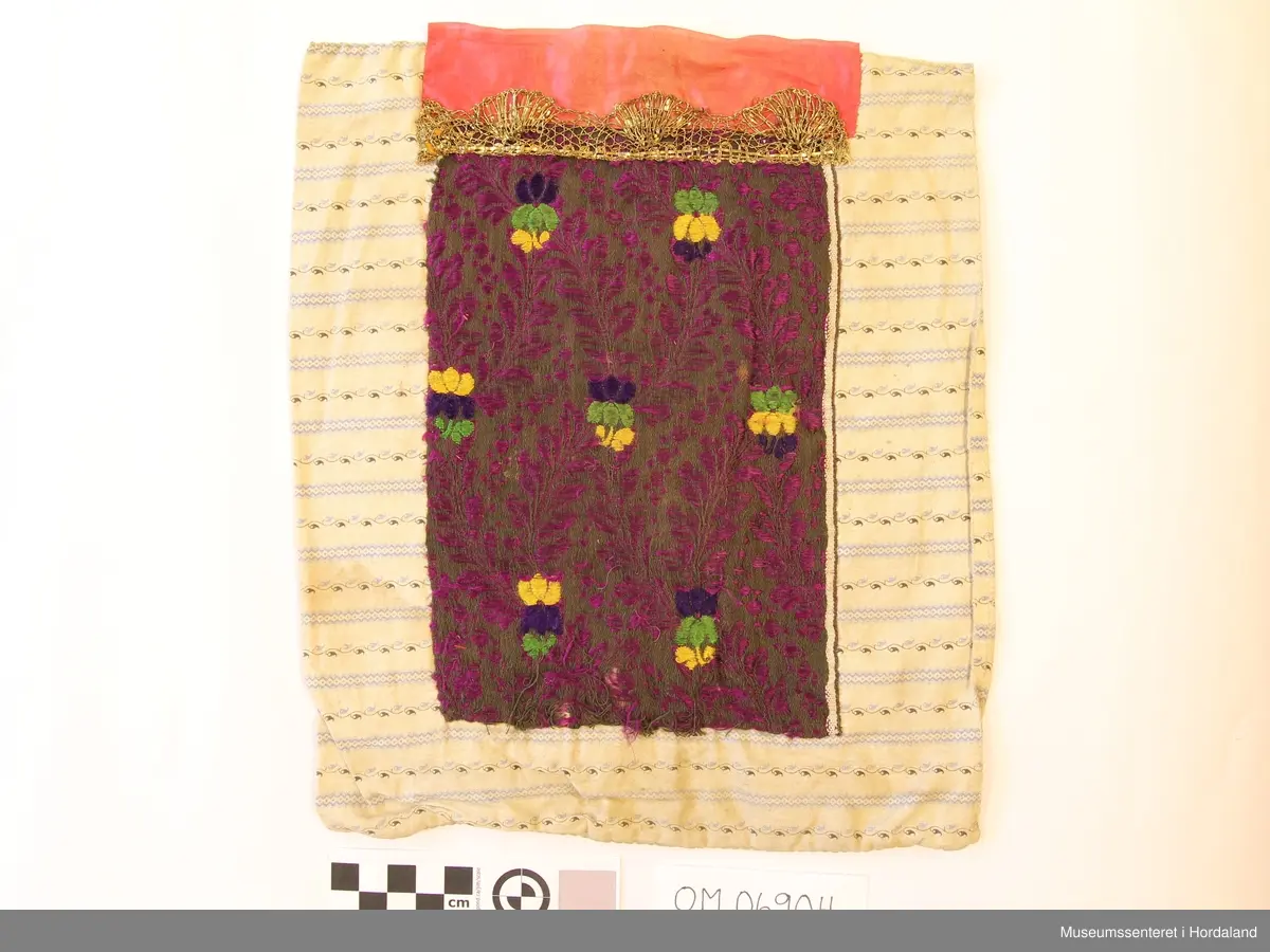 blomstermønster, gullband og rosasilkeband øvst.