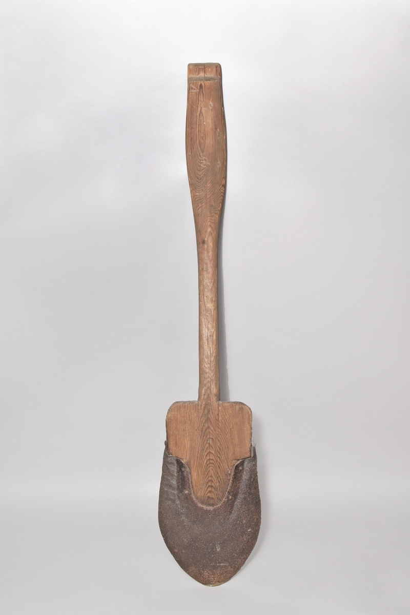 Spade, av barrträ med rundat järnskott blad, skaftet med handvalk, inskuret "A" samt bomärke.