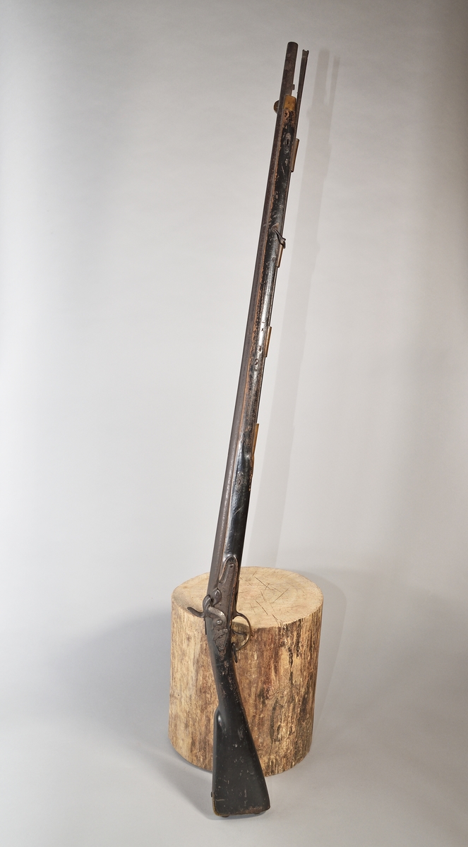 Mynningsladdad bössa med slaglås. Kolv och stock av svartmålat trä, beslag och laddstakshylsor (4 st) av mässing, laddstake av järn, avlångt korn av mässing. Slätborrad pipa. Tjockt låsbleck med varhake (och "stopptapp"). Rutat tumgrepp på hanen. På låsbleck, pipfäste och snäcka stämplat "K"; på stock, låsbleck och pipa "1184"; på sidbeslaget stämplat "I C 41".
Knallhattstappen av.