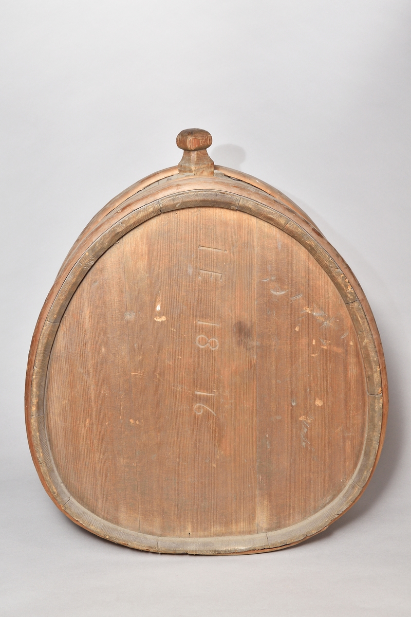 Mjölkflaska, laggad, av barrträ, omålad, oval med platta sidor. I toppen ett fyrkantigt sprund, lös tapp med täljd knopp. Fem laggband av ene, varav ett saknas. Inristat "IE 1816" , "PMI" (?) samt ett bomärke.