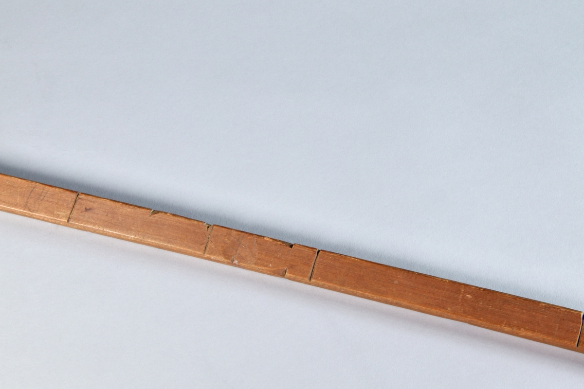 Måttstock, alnmått (dock ej det vanliga alnmåttet). Av furu, med skåror med 14 eller 7 cm mellanrum och hak. I änden inskuren krysstjärna.