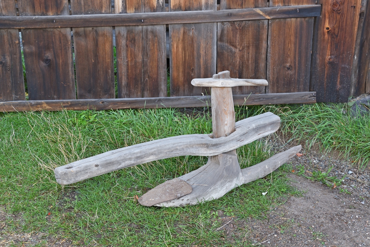 Bågårder av trä med dragåsen trädd över styrbågen; styre och sula ur samma stock, järnbillen satt med 3 nitar på sulans ovansida. Påträtt kort handtag.