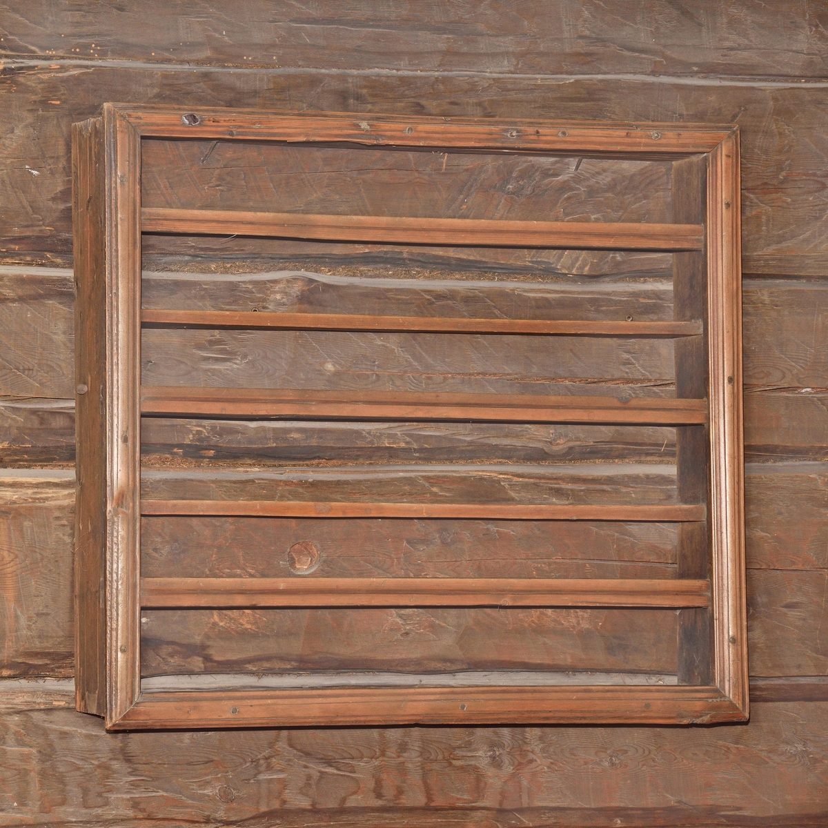 Hylla av omålat barrträ, rektangulär form, väggfast. Ram av brädlappar, randhyvlade kantlister och slåar, två hyllplan, hopsinkad.