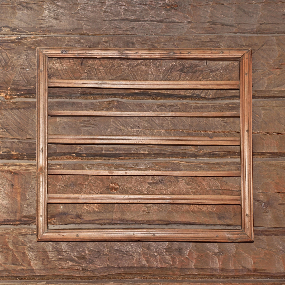 Hylla av omålat barrträ, rektangulär form, väggfast. Ram av brädlappar, randhyvlade kantlister och slåar, två hyllplan, hopsinkad.