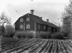 Aspholmen i kvarteret Enhörningen, Jönköping, är fotograferad från väster. Huset uppfördes som utvärdshus av rådmannan J. G. Schmidt omkring 1780. Under sommaren såldes här vin och svagdricka. Sockelns stenar liknar de huggna sandstenar som använts till Göta hovrätts byggnad. Kanske har den höga källaren med sina tre rum under välvda tak byggts av återanvänd sten.