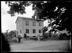 Man med cykel framför hus