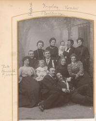 Studioportrett av 13 kvinner, barn og menn.