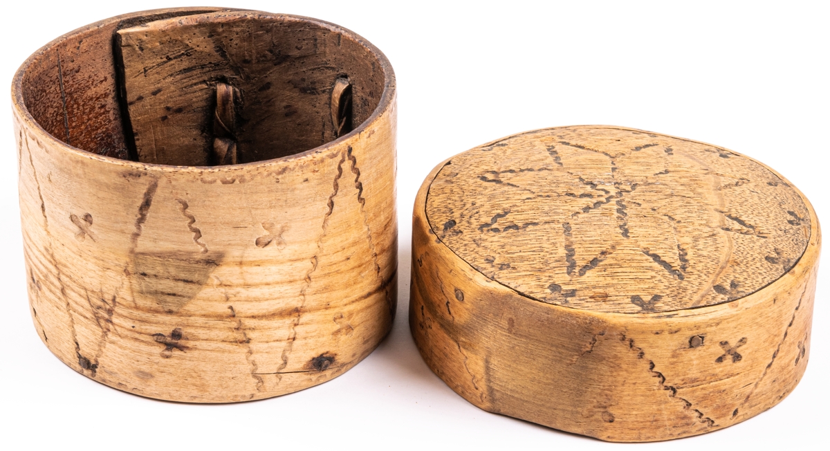 Ask, ornerad genom brännstämpling. I botten märkt 1783.
I svepteknik, rund med lock. Botten och lock av ek. Ornament: fyrbladiga rosor samt krusiga linjer.