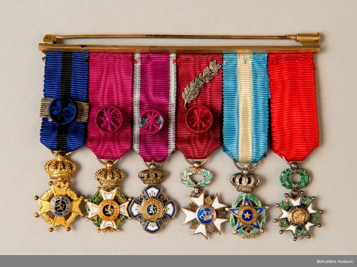 Tolv ordensminiatyrer fördelade och fastsydda på två nålar av guldfärgad metall. 

Ur punktnummerkatalogen 1958-1976:
Kapten E. Göransson, Kungsbacka