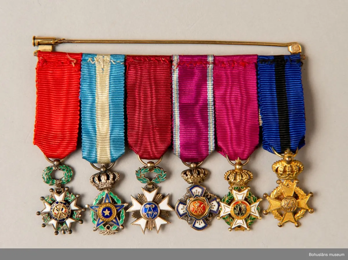 Tolv ordensminiatyrer fördelade och fastsydda på två nålar av guldfärgad metall. 

Ur punktnummerkatalogen 1958-1976:
Kapten E. Göransson, Kungsbacka