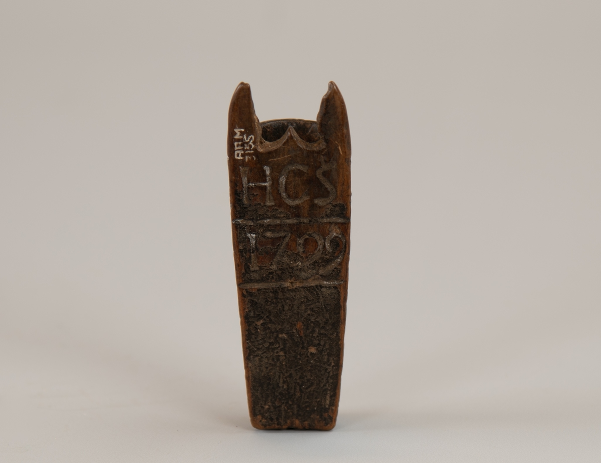 Seilmakerhorn HCS 1799. Av mørkt tre, delvis malt. 
Flatt  på ene side, fasettert på den annen  med   karveskurd.  Innskåret på den flate siden: "   HCS 1799  ".