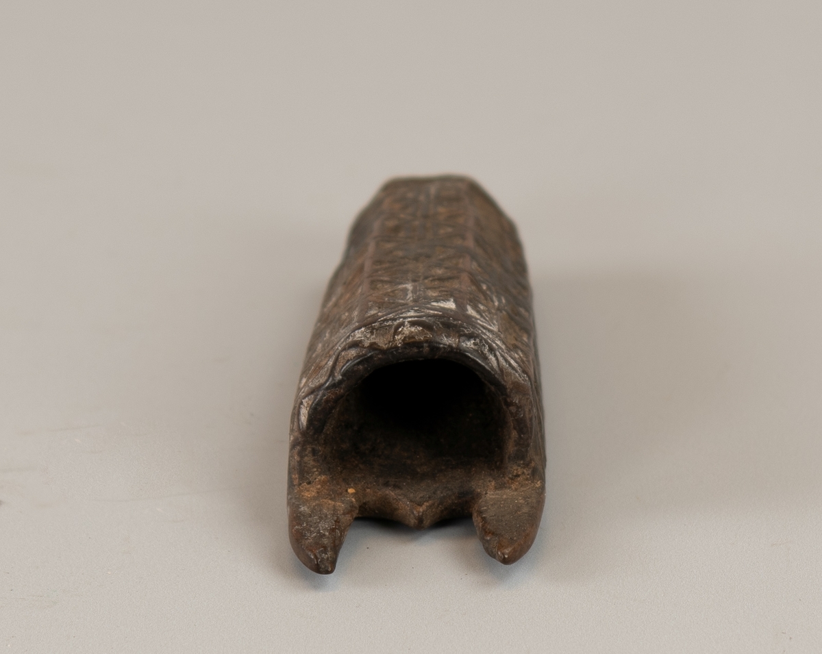 Seilmakerhorn HCS 1799. Av mørkt tre, delvis malt. 
Flatt  på ene side, fasettert på den annen  med   karveskurd.  Innskåret på den flate siden: "   HCS 1799  ".