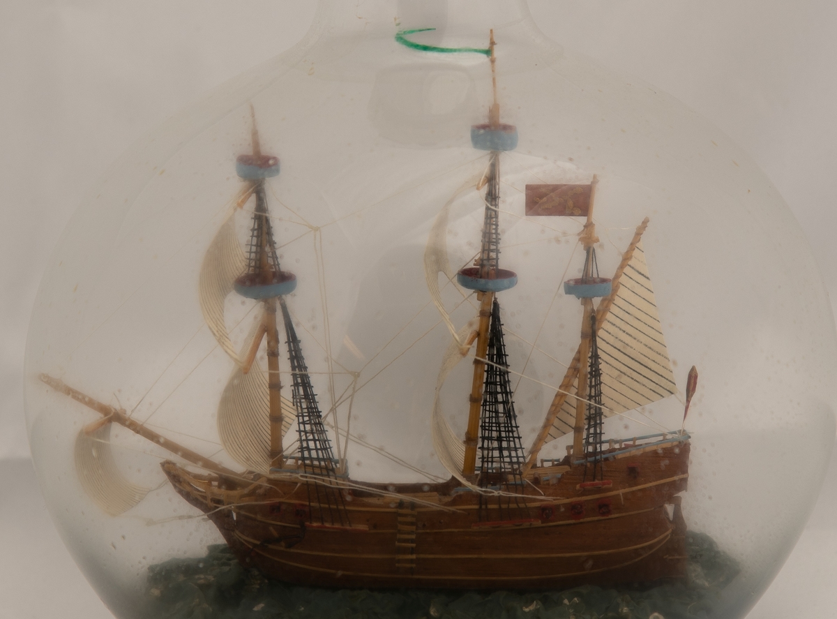 Flaskeskute i en kuleformet flaske: Derffling , 1675. Brandenburg (overgangstype mellom galeon og fløyte) .  Skuta har Tremaster , oppbygget akter, og brunt skrog med små detaljer i rødt og sort , lysblåt og rødt. Blå kruset sjø.