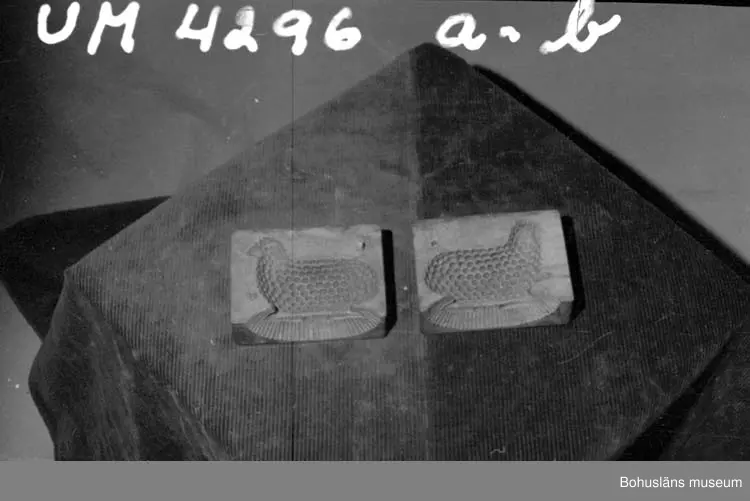 Tvådelad smörform som formar smöret till ett liggande lamm.

Ur handskrivna katalogen 1957-1958:
Smörformare
I 2 delar, a-b, mått (hopsatt)13,5 x 10,3 x 7,8 cm, av trä, omålat; form till höna el. dyl. Hel.