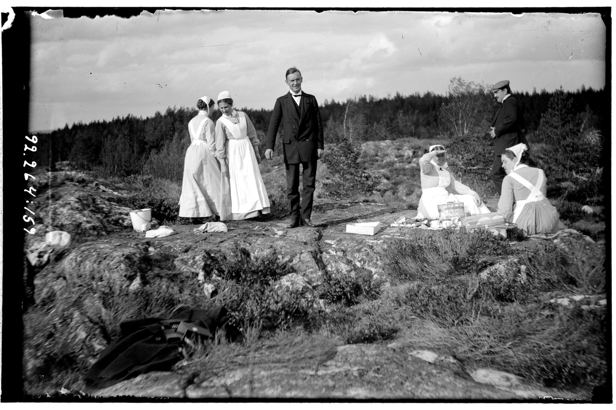 Hålahult sanatorium, exteriör, fyra kvinnor i uniform två män i kostym, i naturen på ett berg