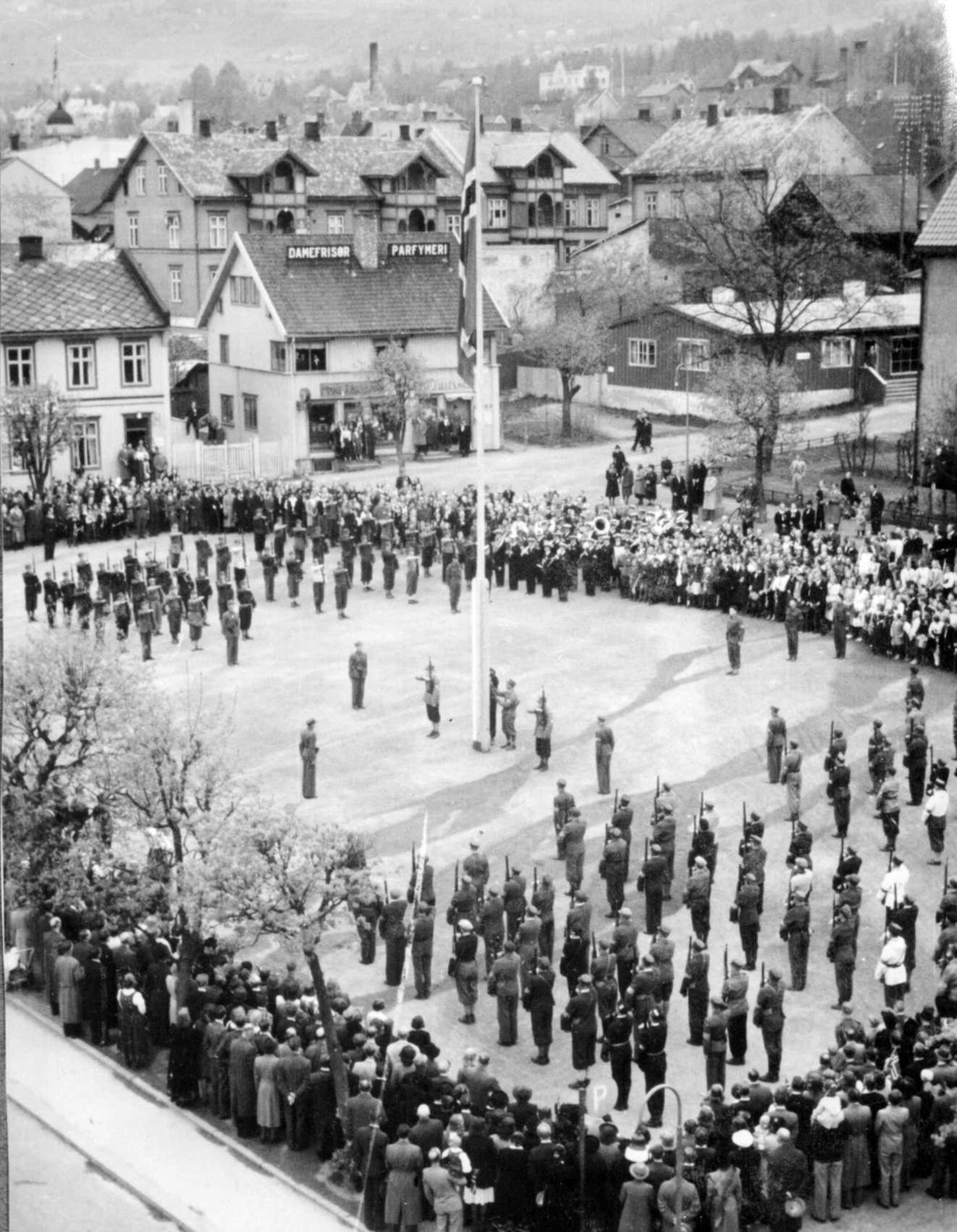 Repro: Hjemmestyrkene paraderer på Stortorget, Lillehammer og heiser flagget 17. mai 1945.