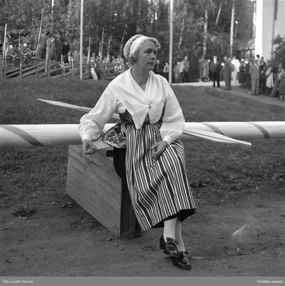 Motiv: (ingen anteckning) ;
En kvinna och två män spelar boccia, porträtt av en kvinna i folkdräkt, en folksamling står vid en gärsgård, tre män i folkdräkt rider på hästar framför män som spelar fiol och kvinnor i folkdräkt som går på en väg "Midsommartåget till Tibble", en kvinna i folkdräkt rider på en häst som drar en vagn med barn, kvinnor och män pryder en midsommarstång med lövade ringar.dju