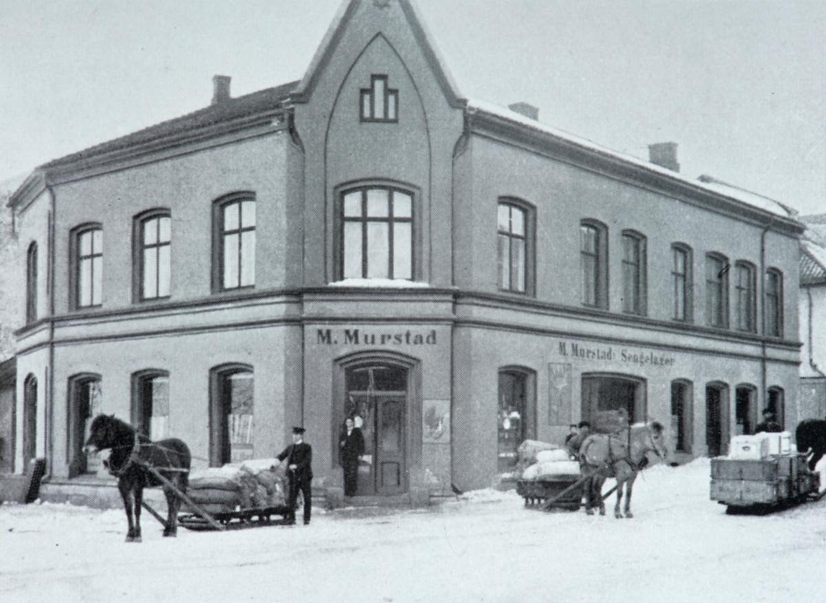 Maleri, kunst. Bilde malt av Gina Harboe i 1938. Bygården til M. Murstad i Lille Strandgate 3, Storhamargata 12. (i dag Bazarene)  Under treet t.v. i bildet, benker og bord,  der Kaisa solgte sin søtsuppe, populært kalt "Kaisasuppe" og sine kjøttkaker.