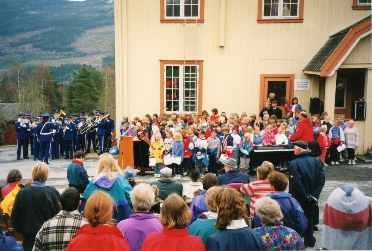 Gruppe,bunad,musikkorps.
Gudrun Larsgard Bøthun er på talarstolen.